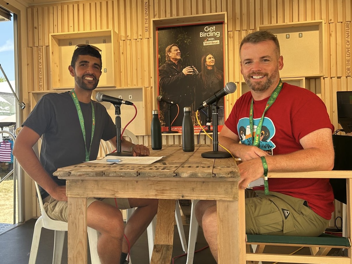 Ajay Tegala interviews Sean McCormack at Global BirdFair Two men sat on a stage, each with a microphone in front of them