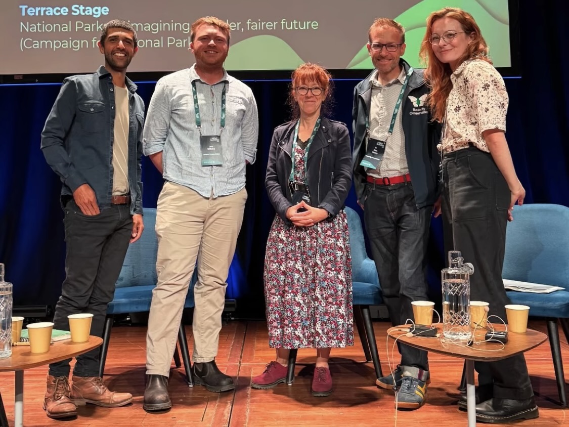 Ajay Tegala chairs a panel at the Wild Summit Five smiling people stood together on stage